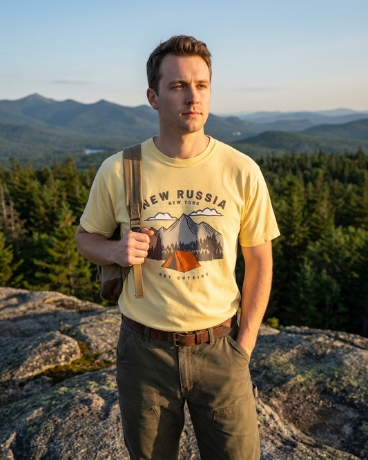 Man standing on a mountain with a scenic background wearing a 'New Russia' t-shirt.