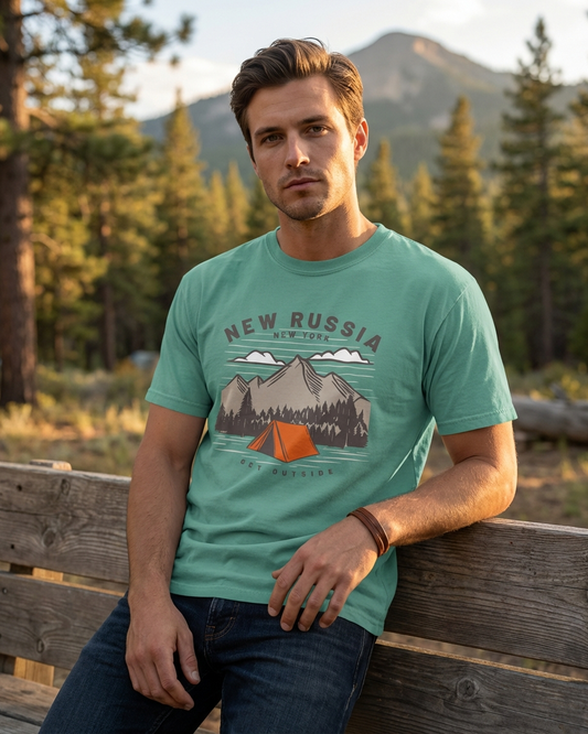 Man wearing a green t-shirt with 'New Russia' design in a forest setting